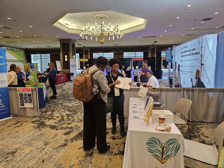 LaMé Essentials team member showing the Supervision Journal to an attendee