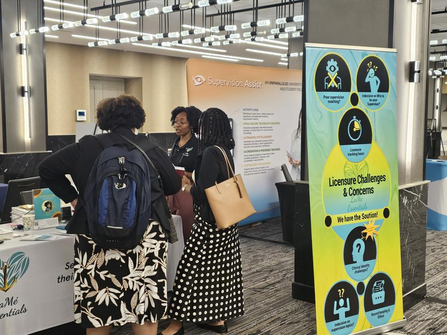 Attendees talking with the LaMé Essentials team at the booth